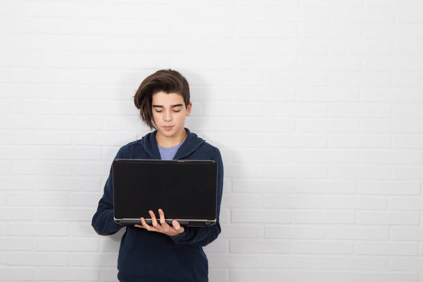 young man with computer isolated in white wall - 写真・画像