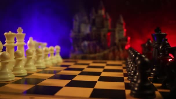 Schaken bordspel concept van bedrijfsideeën en concurrentie en strategie ideeën concep. Chess cijfers op een donkere achtergrond met rook en mist. - Video