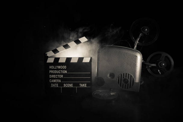 Oude vintage filmprojector op een donkere achtergrond met mist en licht. Concept van film maken. Selectieve focus - Foto, afbeelding