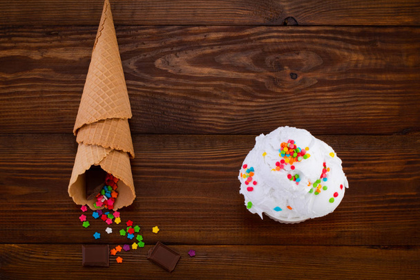 тарелка ванильного мороженого совок с брызгами и вафельным конусом
 - Фото, изображение