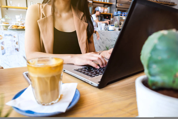 Beautiful asian women typing on laptop in coffee shop - Photo, Image