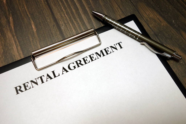 Clipboard with rental agreement mockup and pen on desk - Photo, Image