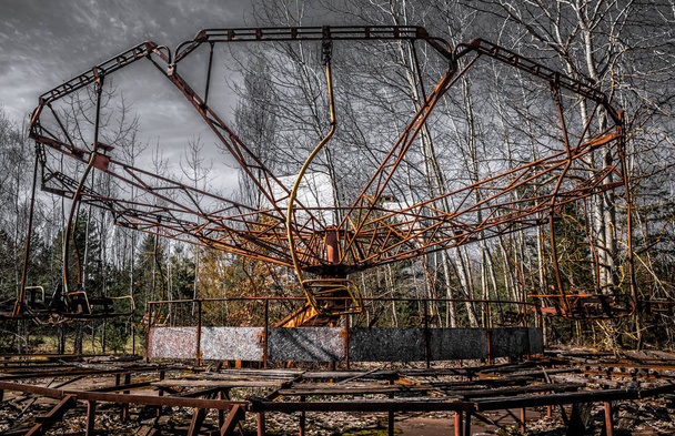 Repère célèbre de la ville abandonnée de Pripyat, en Ukraine. Vieille roue rouillée. Désolation et dévastation dans la zone d'exclusion après une explosion nucléaire à la centrale nucléaire de Tchernobyl
 - Photo, image