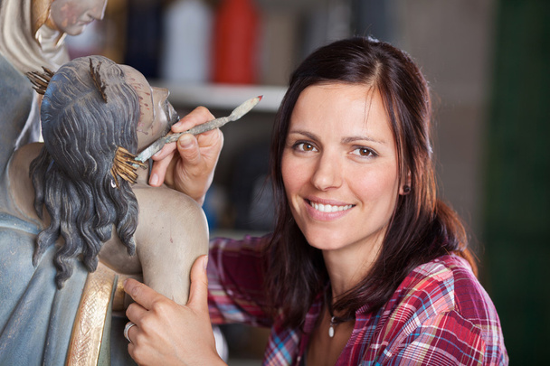 Smiling Female Artist Cleaning Statue With Spatula - Foto, Imagem