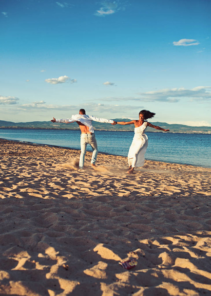 Summer holidays and travel vacation. Love relations of dancing couple enjoying summer day together. Couple in love dance on beach sand. Family and valentines day. Sexy woman and man at sea - Foto, Imagem