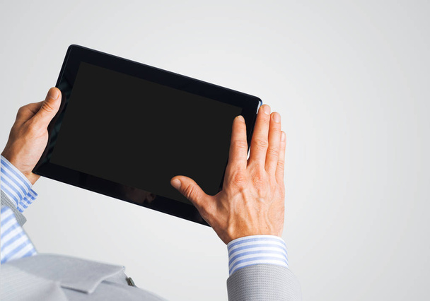 Hands of businessman holding tablet pc with black screen - Fotó, kép