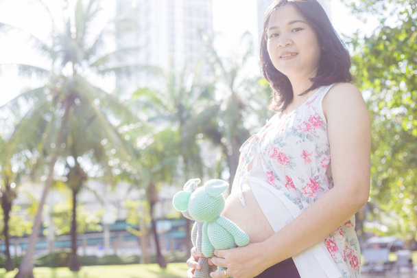 Asiatico incinta donne in posa in città pubblico verde parco
 - Foto, immagini