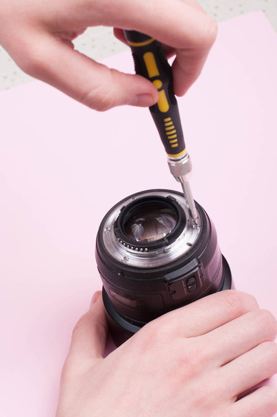 Camera lens repair. Pink lights repairing service concept. - Photo, Image
