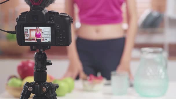 asiatische Bloggerin Frau machen vlog, wie man sich ernährt und abnimmt, junge Frau mit Kameraaufzeichnung, wenn sie Joghurt in der Küche isst. Lifestyle Influencer Frauen gesundes Konzept. - Filmmaterial, Video