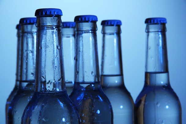 Water bottles on blue background - Foto, afbeelding