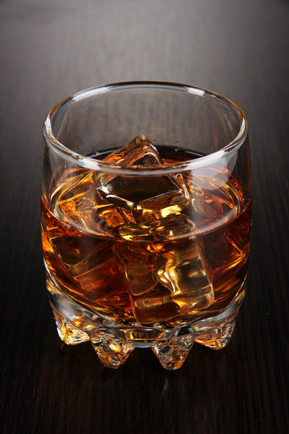 Brandy glass with ice on wooden background - Fotoğraf, Görsel