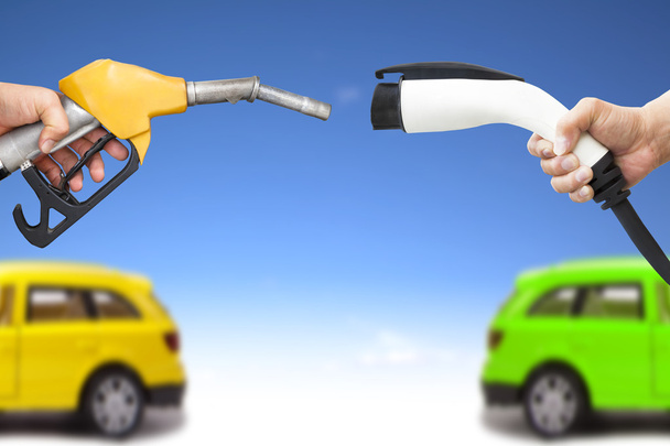 elektromos autó- és benzinüzemű autó fogalma. kezében gáz-szivattyú és - Fotó, kép
