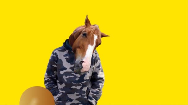 Imbolygott ember egy ló fejét és a repülő sárga léggömbök, vicces szerencsekívánat helyet a szöveg, 4k videó - Felvétel, videó