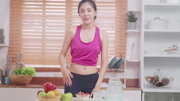 Asian blogger kobieta zrobić Vlog jak do diety i stracił wagę, młoda kobieta za pomocą aparatu nagrywania, gdy ona jeść jogurt w kuchni. Lifestyle influencer kobiety zdrowy pojęcie. - Materiał filmowy, wideo