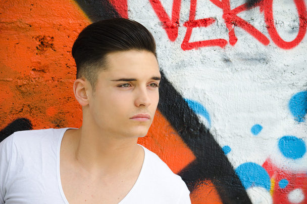 Good looking young man against graffiti wall - 写真・画像