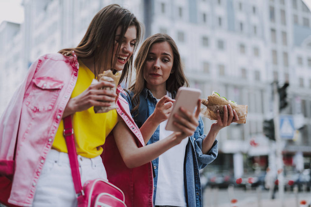 Χαρούμενα θηλυκά ελέγχουν το κινητό διάλειμμα γεύμα - Φωτογραφία, εικόνα