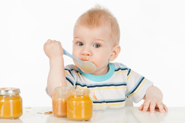Boy eats with a spoon puree - 写真・画像