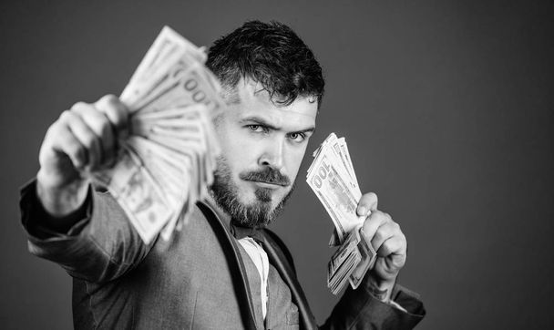 Making money with his own business. Rich businessman with us dollars banknotes. Currency broker with bundle of money. Bearded man holding cash money. Business startup loan. Cash in hand - Фото, зображення