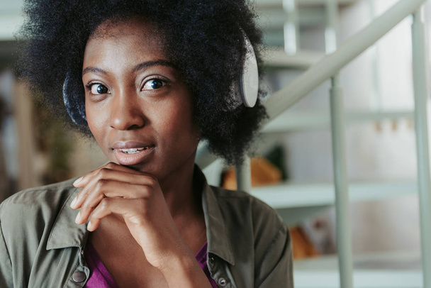 Calm African woman wearing headphones and looking at camera - Zdjęcie, obraz