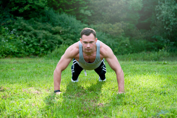 Man doing fitness exercise on the grass - Photo, image
