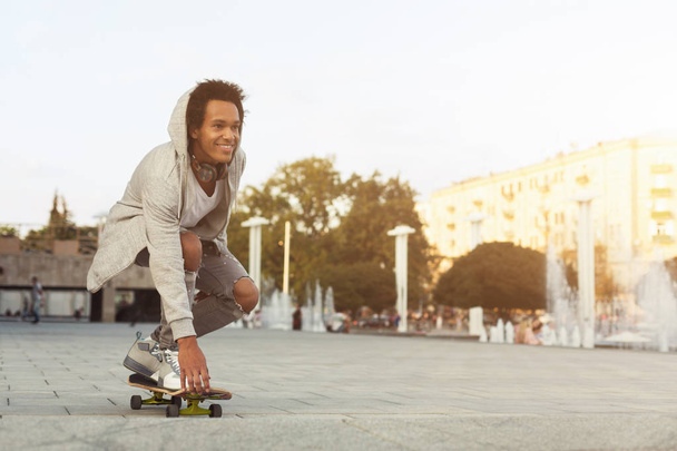 African American teen Guy skateboarden op de zomeravond - Foto, afbeelding