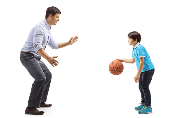 Full length shot of father and son playing basketball isolated on white background - Foto, immagini