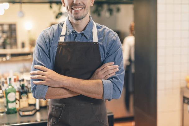 Close up of smiling barista with crossed arms - 写真・画像