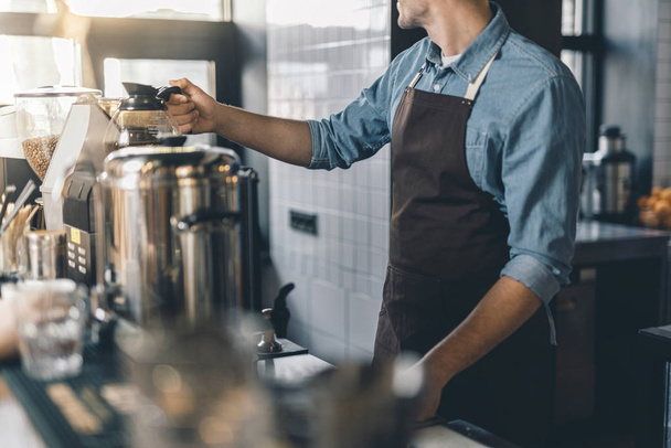 Barista kahve makinesinin üstüne kahve sürahi yerleştirerek - Fotoğraf, Görsel