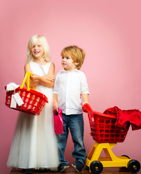 Girl and boy children shopping. Couple kids hold plastic shopping basket toy. Kids store. Mall shopping. Buy products. Play shop game. Cute buyer customer client hold shopping cart. Buy with discount - Foto, Bild