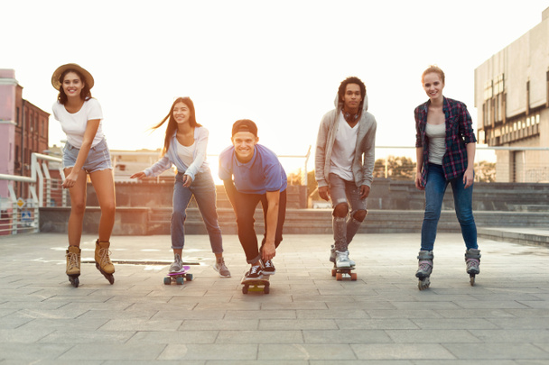 Adolescentes felices divirtiéndose, montando en patinetas y rodillos
 - Foto, Imagen