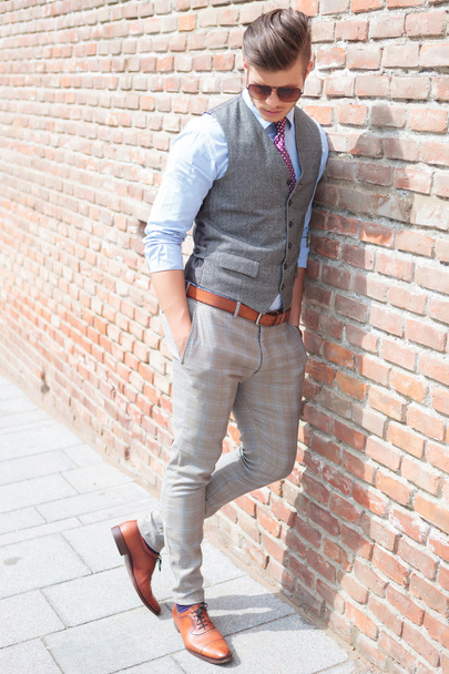 casual man leans on wall and looks down - Foto, Imagem