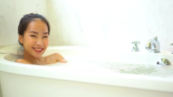 Кадри красивою азіатською молодою жінкою беручи міхур ванни - Кадри, відео