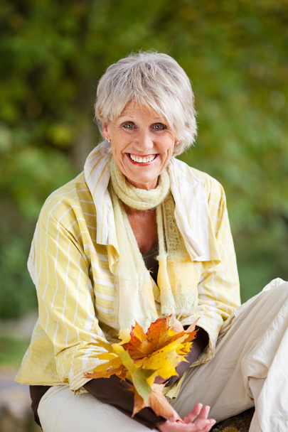 Happy Senior Woman Holding Autumn Leaves - Foto, Imagen