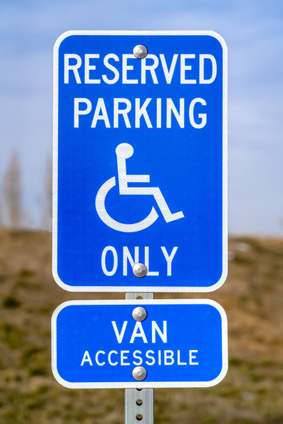 Синій зарезервований знак парковки Ван Доступний з людиною на іконці інвалідного візка
 - Фото, зображення