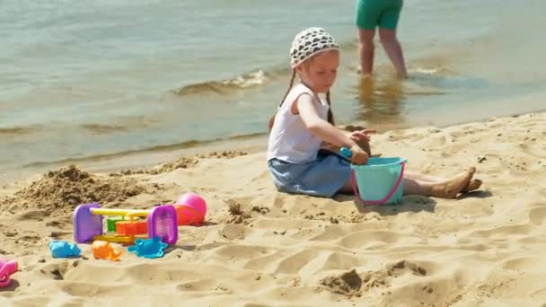 Children playing on the beach by the river on a sunny day - Footage, Video