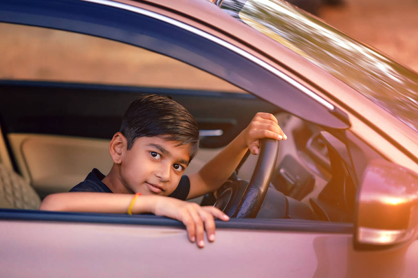 Cute Indian child in car - 写真・画像