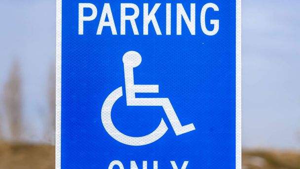 Панорама Блакитна зарезервована парковка Ван доступні підписати з чоловіком на інвалідному візку значок - Фото, зображення