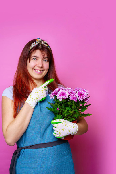 Photo of cheerful woman with chrysanthemum pointing hand to side - Фото, изображение
