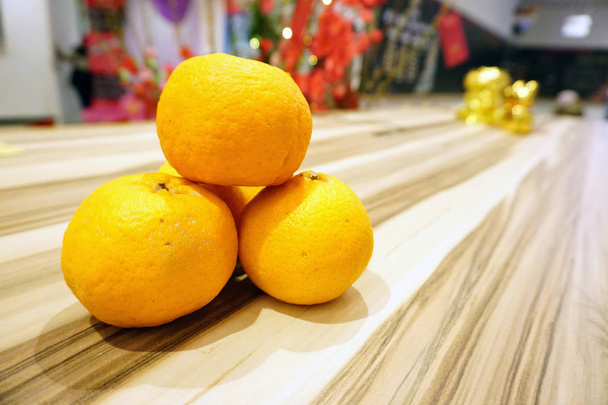 Mandarijn sinaasappelen of LOKAM over houten achtergrond voor Chinees Nieuwjaar viering. Selectieve focus - Foto, afbeelding