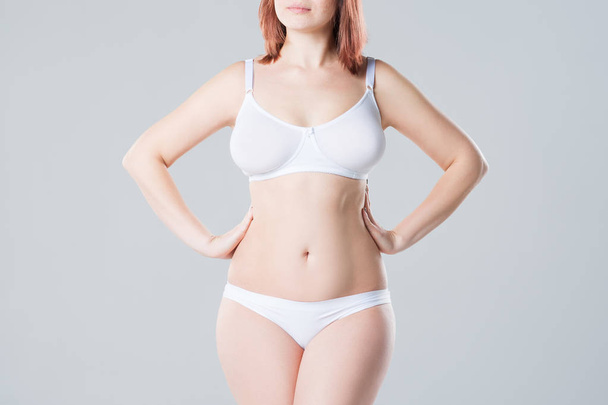 Young slim woman in underwear on grey background, beautiful female body - Photo, Image