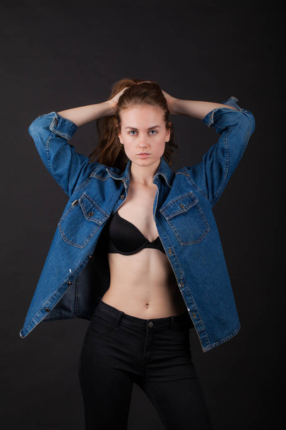studio portrait of a very thin young woman in lingerie with wet hair and jeans jacket - Foto, Bild