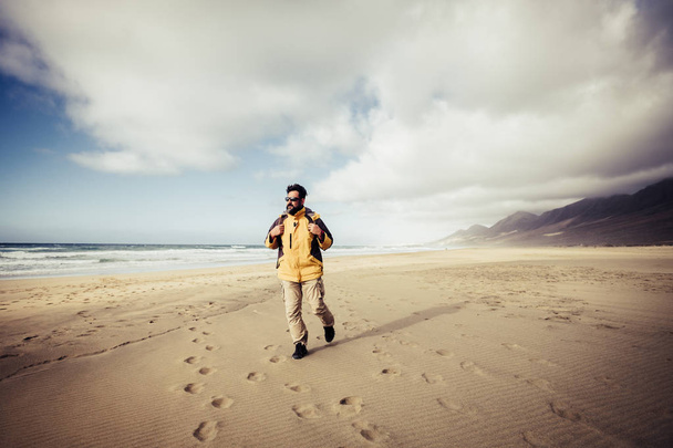 férfi hátizsákos járás homokos tengerpart, utazás és a szabadság fogalma  - Fotó, kép