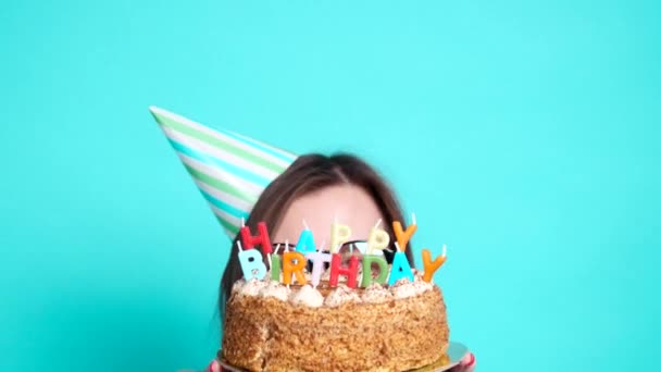 Koncepció az ünneplés és a szórakozás. Fiatal vidám vicces lány születésnapi tortával - Felvétel, videó