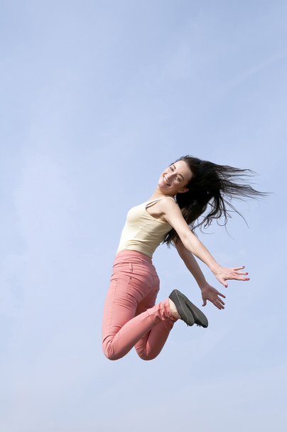 Nainen hyppää siniselle taivaalle
 - Valokuva, kuva
