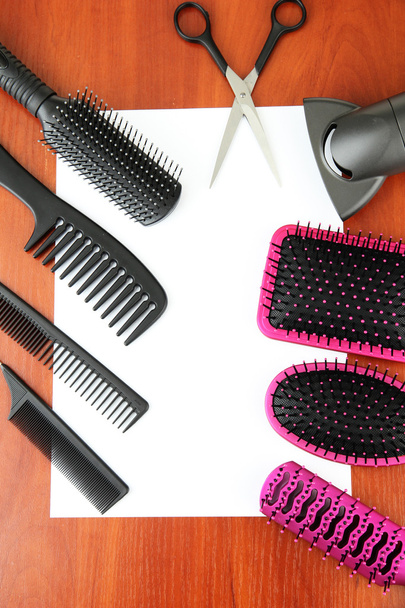 Comb brushes, hairdryer and cutting shears,on wooden background - Foto, afbeelding