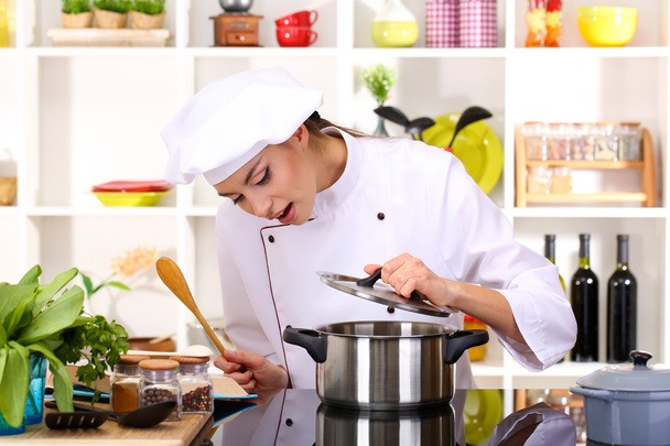 Young woman chef cooking in kitchen - Foto, Imagen