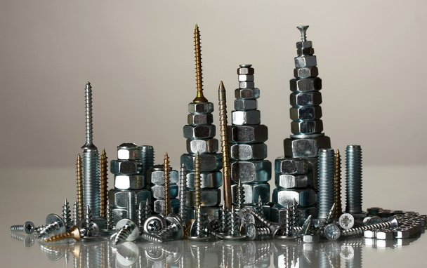 Many types of metal bolts, screws and nuts on grey background - Fotoğraf, Görsel