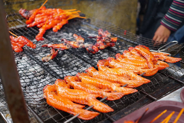 Herkullinen kuuma mausteinen grillattu kana siivet paikallisilla markkinoilla myytävänä
 - Valokuva, kuva