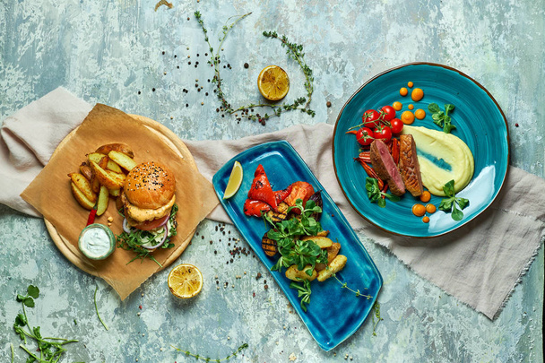 Три страви з м'ясним бургер з овочами на грилі
 - Фото, зображення