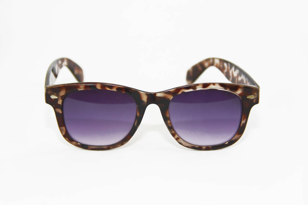 lunettes de soleil dans une monture en plastique marron et lentilles violettes sur fond blanc
 - Photo, image